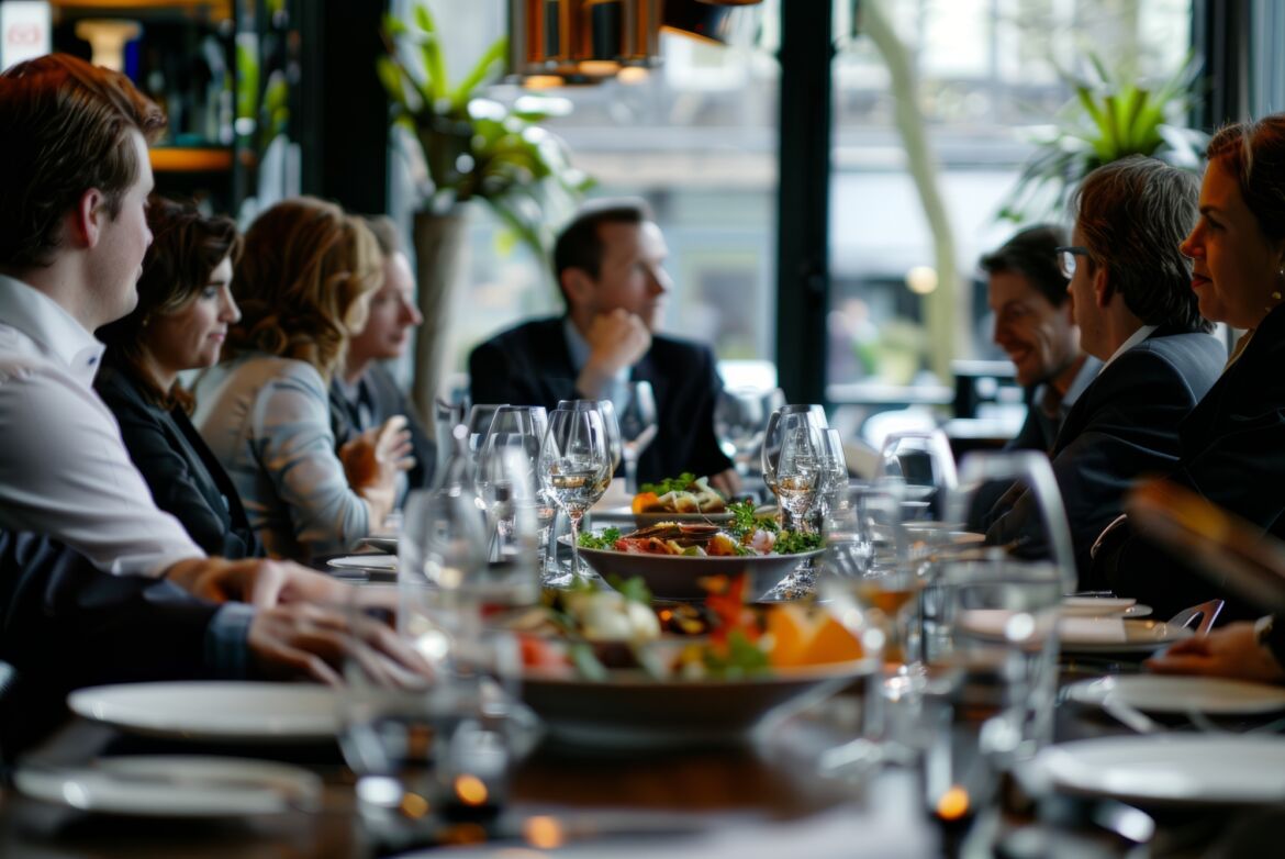 people sit at a long table for dinner and conversation.