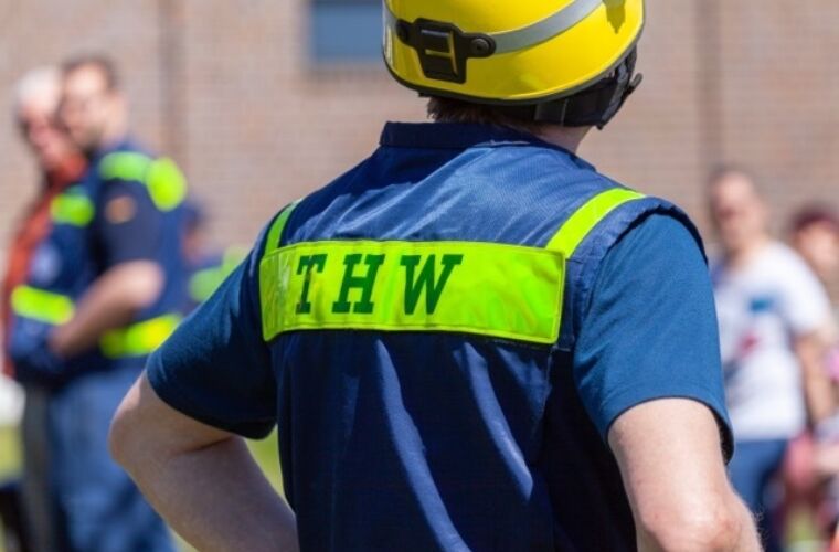 Mitarbeiter:in vom THW in Uniform von der Rückseite In Nahaufnahme zu sehen.