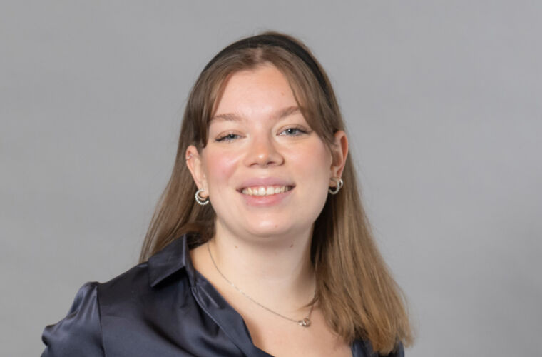 Cara Dedina, with glasses, looking head-on into the camera.